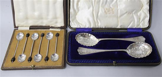 A cased pair of ornate Edwardian silver spoons and a cased set of six bean end coffee spoons.